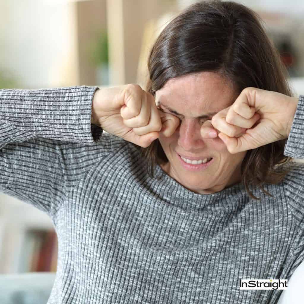 Lady vigorously rubbing her eyes under title Why Does Keratin Burn My Eyes?